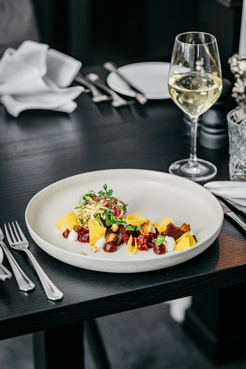 Gourmetgericht mit Weißwein im Hotel Riesengebirge Restaurant.